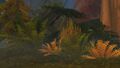 A statue hidden in the brush, reminiscent of those found in troll ruins on Azeroth.